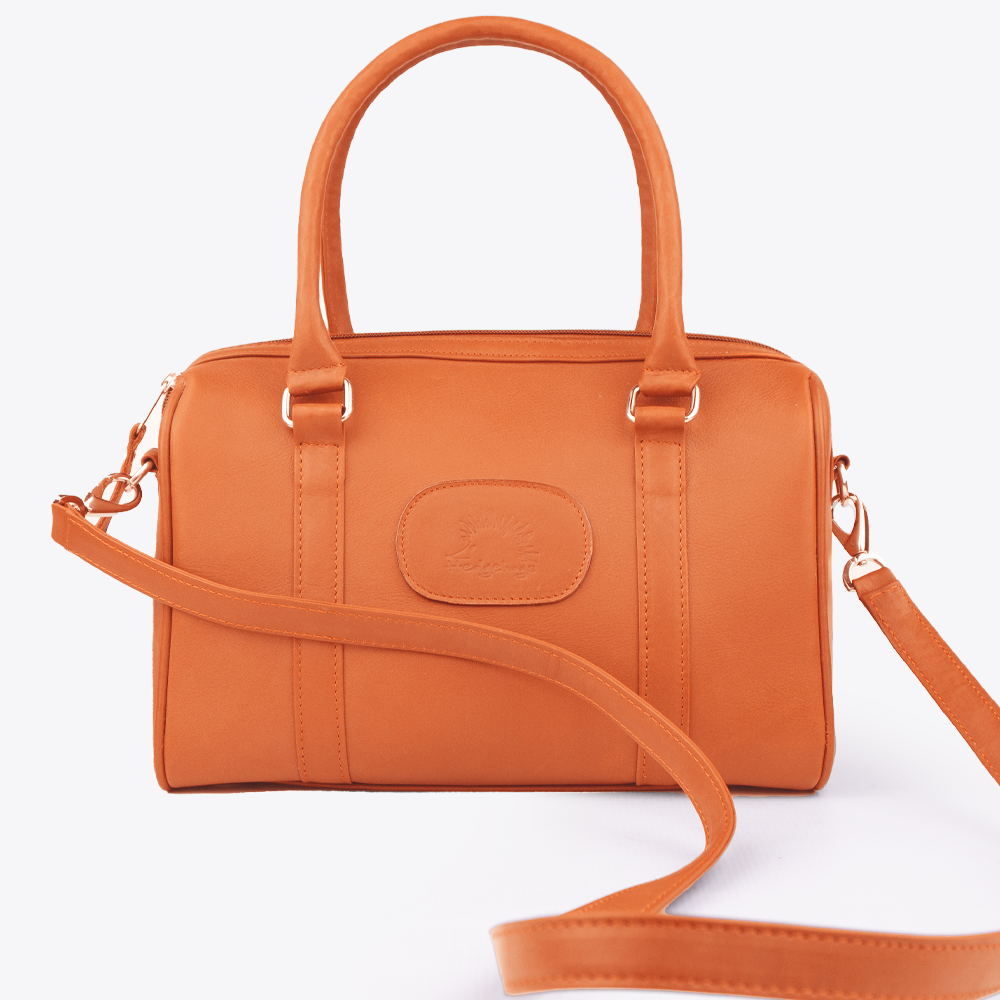 Detail showing the carry handles and the detachable leather cross-body strap on the Hedgehogs Coral Bowler Bag