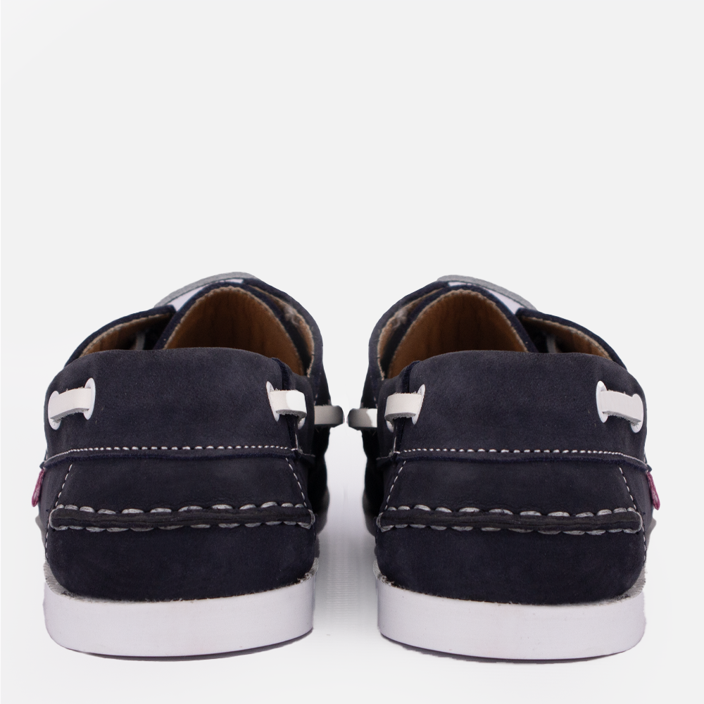 Rear view of a pair of the Hedgehogs Bianca boat shoe in navy nubuck, showing the white contrast stitch and lace detail.