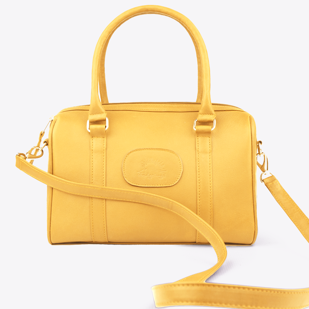 View of the Hedgehogs Bowler handbag in ochre leather showing the detachable crossbody strap. 