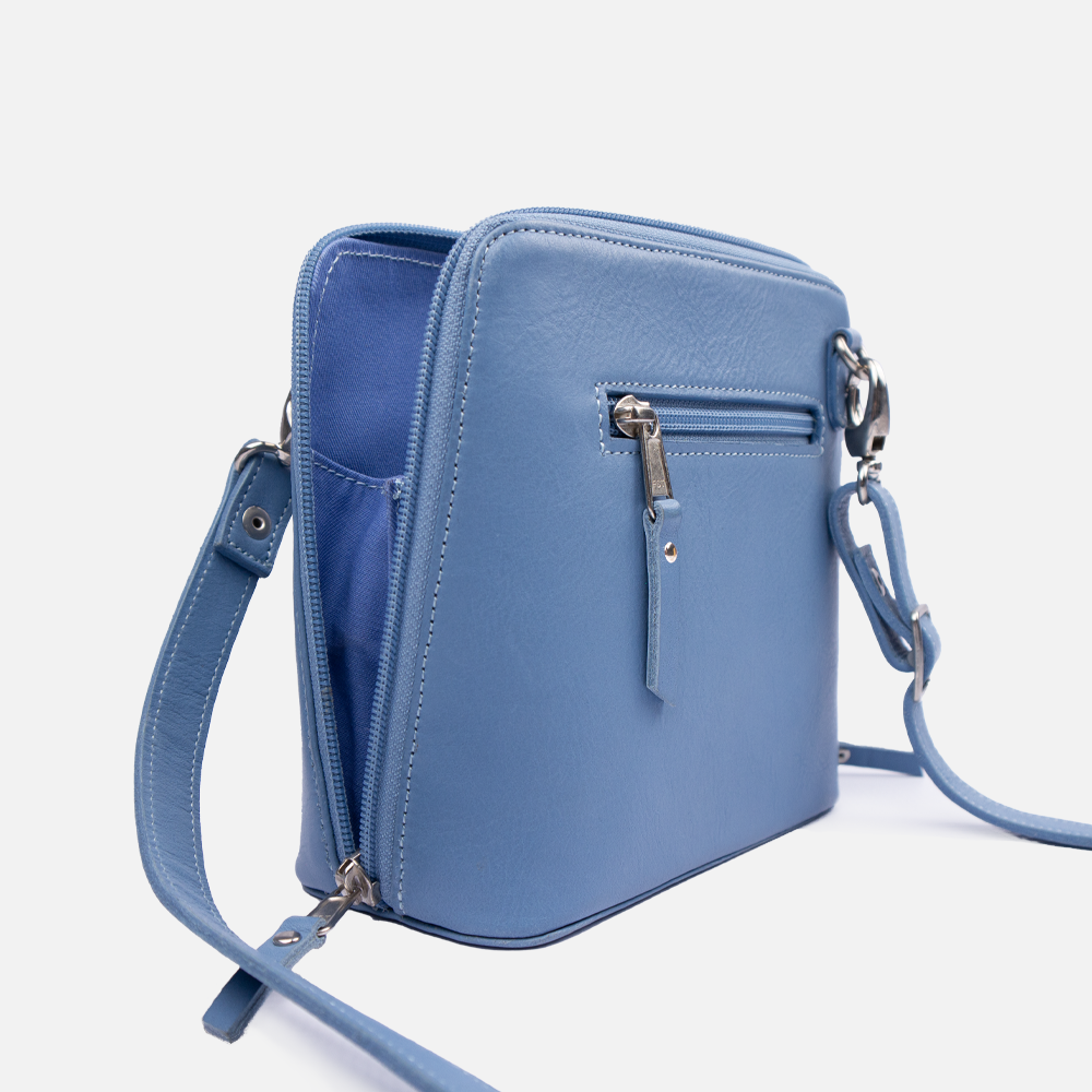 Side view of the Hedgehogs clutch bag in baby blue leather showing the detachable strap, zip closure and matching blue internal lining. 