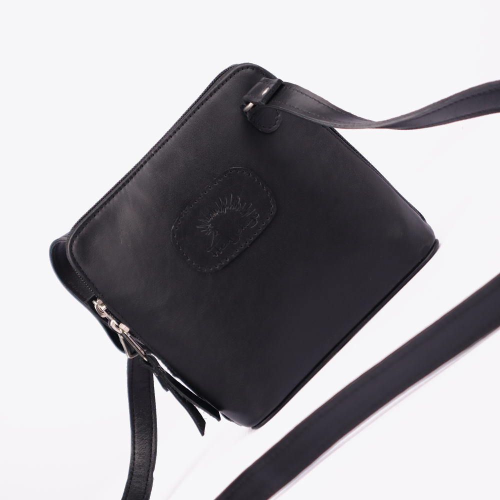 View of the Hedgehogs clutch bag in black leather showing the brand embossing and crossbody strap detail