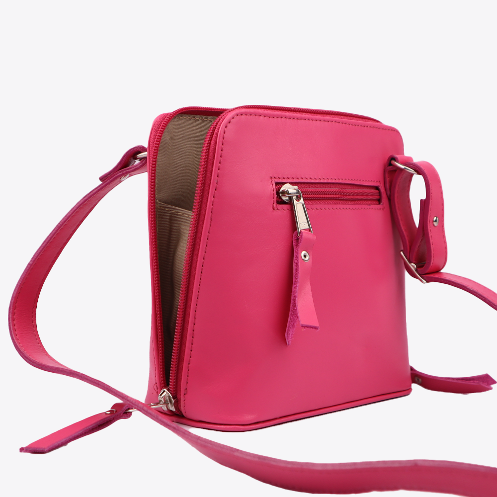 Side view of the Hedgehogs clutch bag in cerise pink leather, showing the crossover strap, zip closure and external pocket detail.