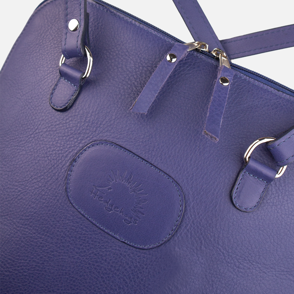 Close up view of the Hedgehogs ladies convertible backpack in indigo leather, showing the zip detail