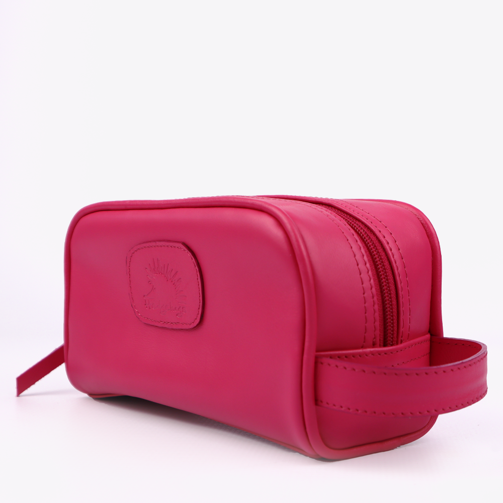 Side view of the Hedgehogs ladies toiletry bag in cerise pink leather, showing zip and side handle detail.
