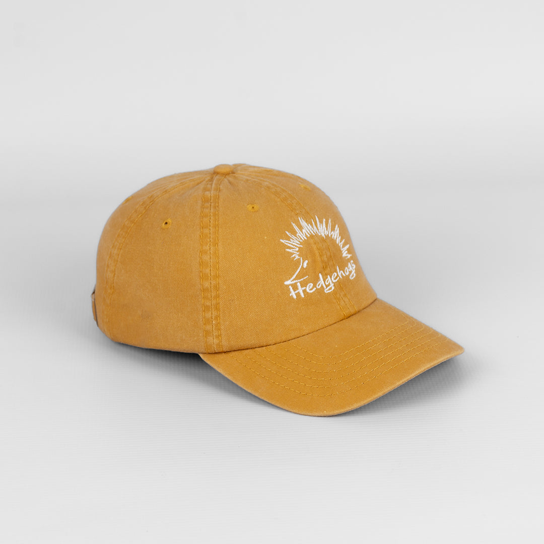 Side profile of the Hedgehogs Mustard Washed Cotton Cap, showing the relaxed shape.