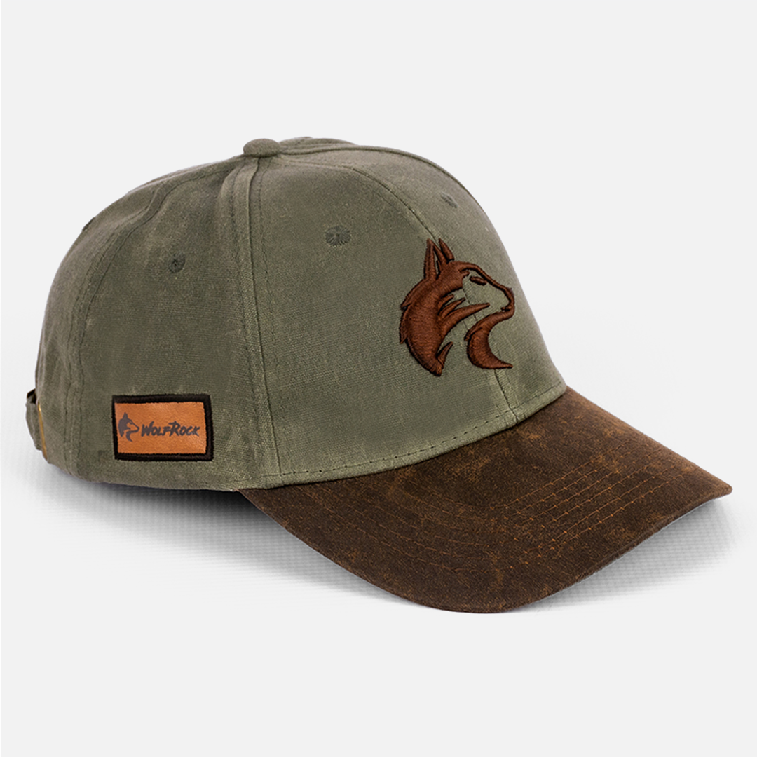 Angled view of the Wolf Rock Waxed Cotton Cap, showing detail of the waxed cotton fabric and the embroidered logo on the cap