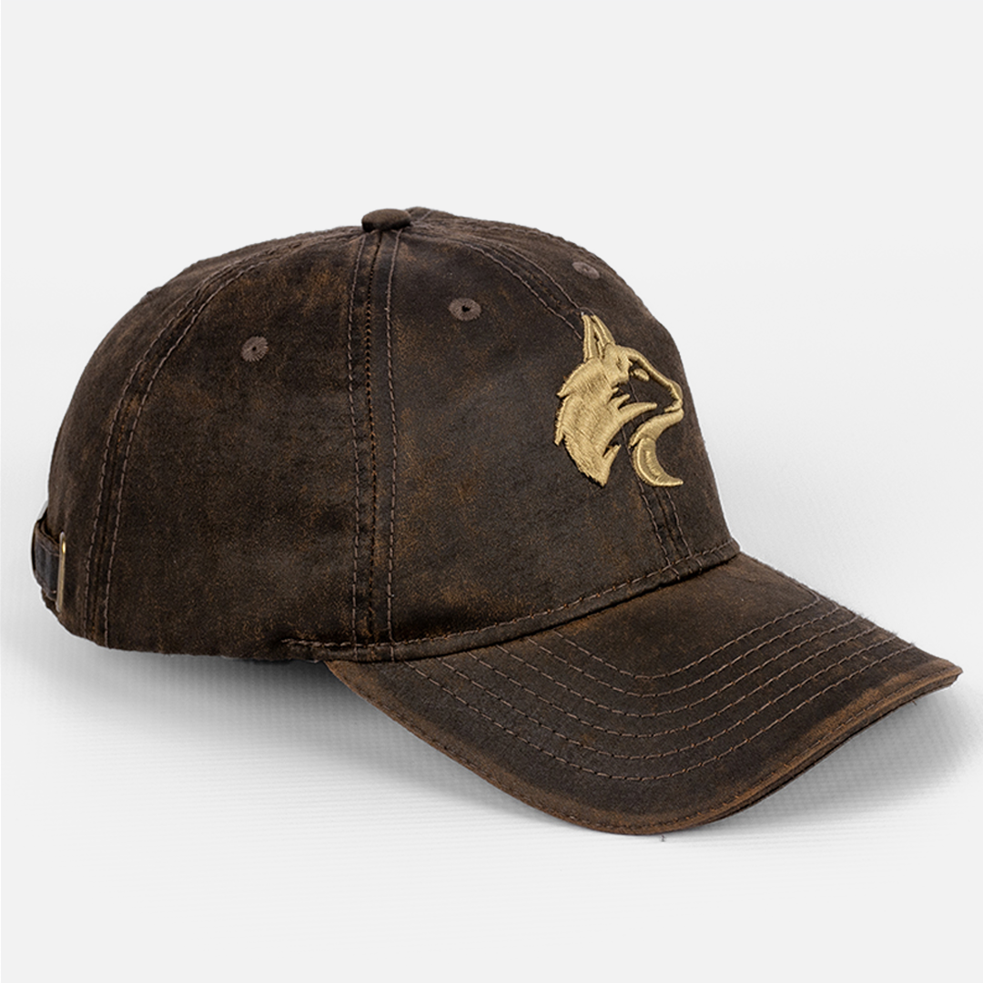 Angled view of the Wolf Rock Brown Oil Skin Cap showing the waxed texture and embroidered logo. 