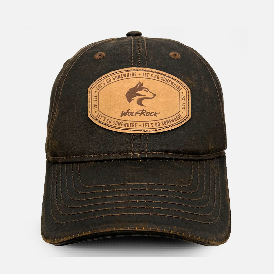 Front view of the Wolf Rock Brown Oil Skin Cap with the stitched leather logo patch.