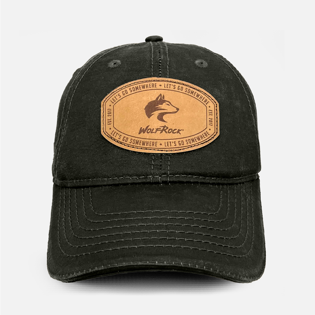 Front view of the Wolf Rock Oil Skin Cap in Olive with the stitched leather logo patch.