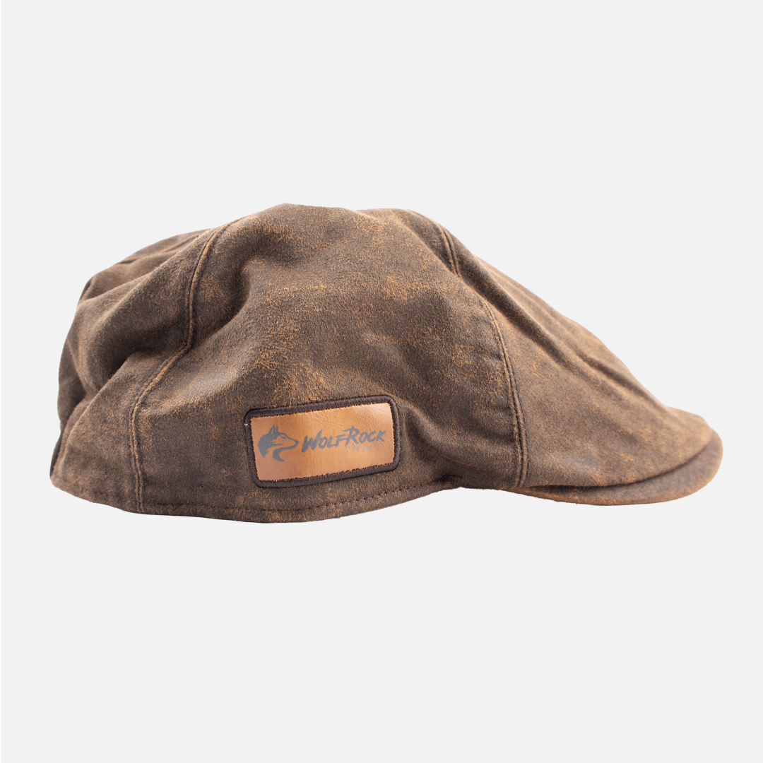 Alternate side view of the wolf Rock Oilskin Flat Cap in chocolate brown, showing side leather patch detail.