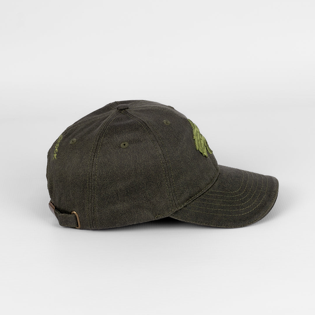 Side profile of the Olive Oil Skin Cap showing the peak and crown shape.