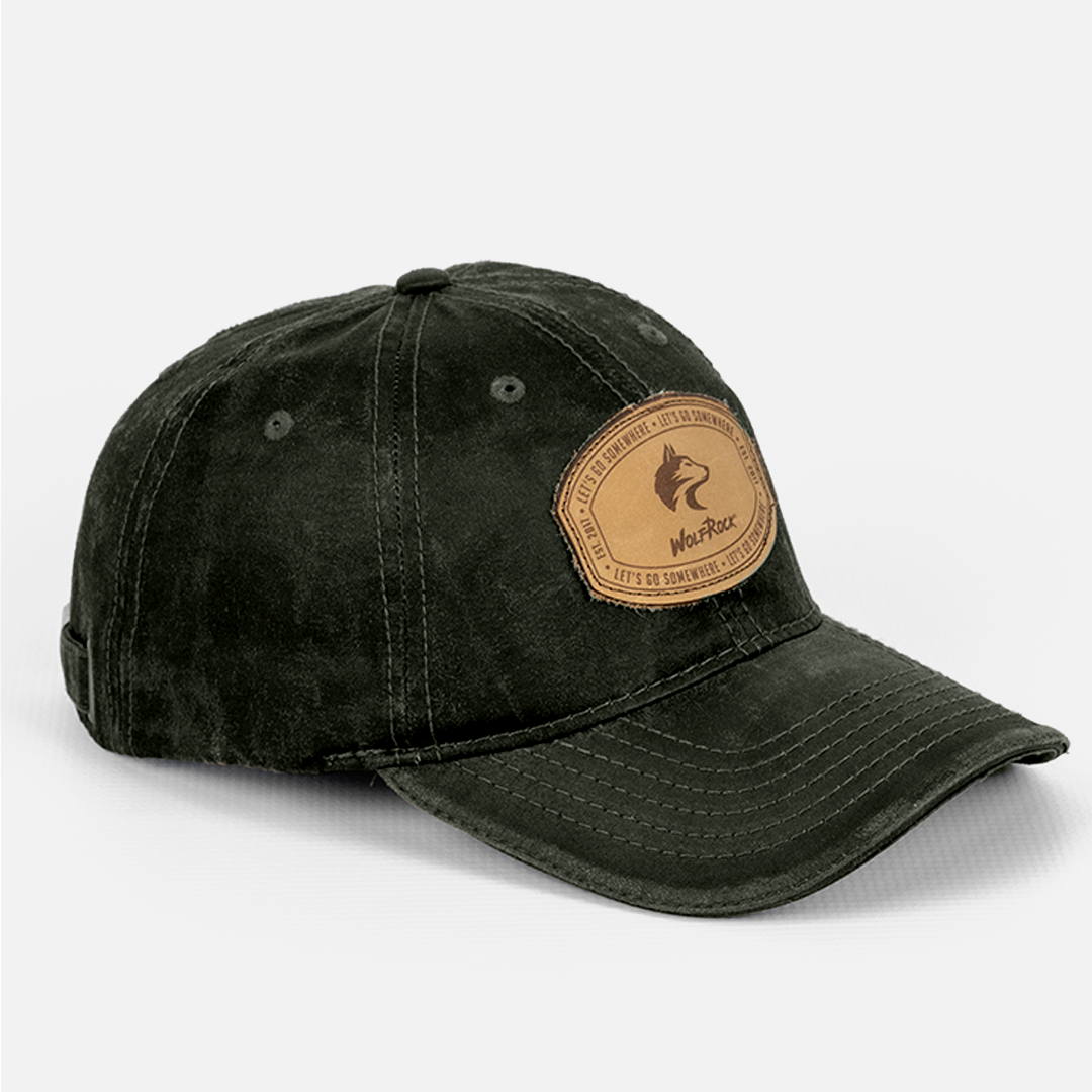 Side profile of the Wolf Rock Oil Skin Large leather patch cap in olive. 